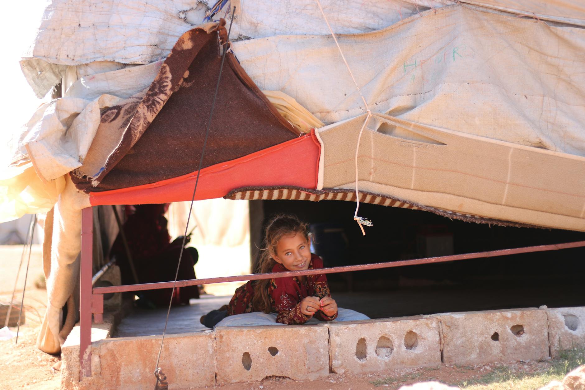 Dziewczynka leży w prowizorycznym namiocie w Idlib w Syrii