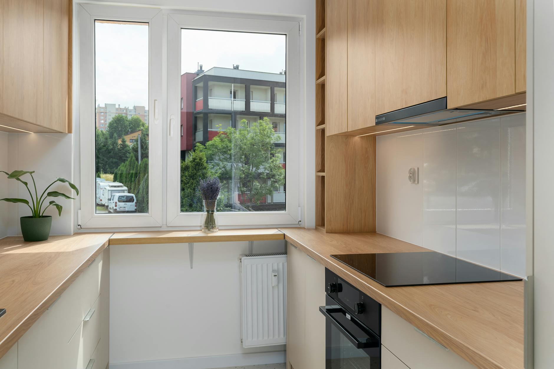 Nowoczesna, mała kuchnia z drewnianymi szafkami i widokiem na Kraków