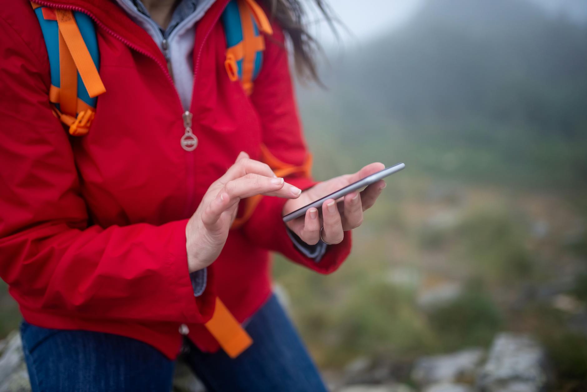 Turysta w górach korzystający ze smartfona we mgle