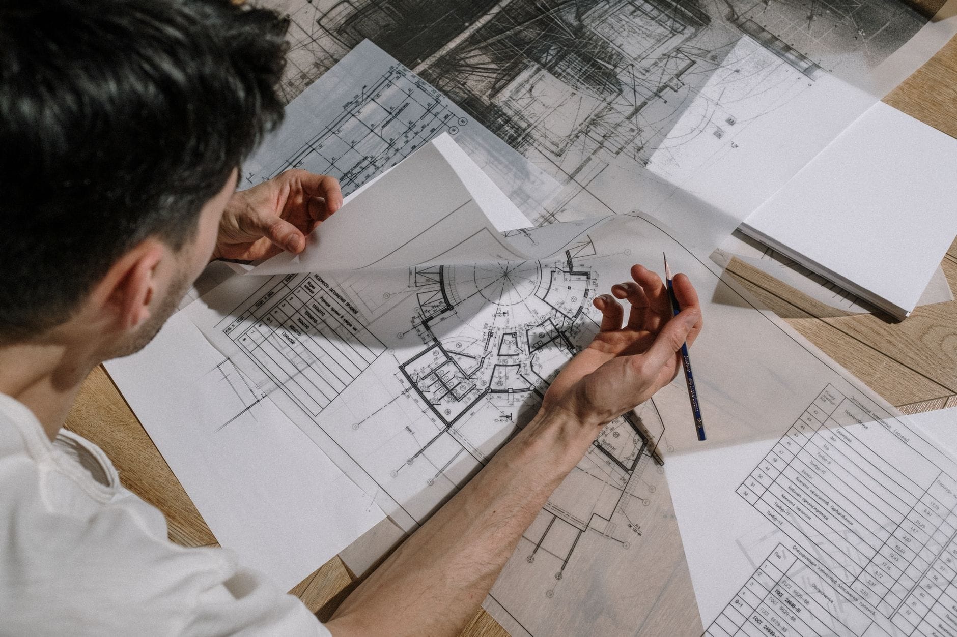 Pozwolenie na budowę a zgłoszenie robót budowlanych: kluczowe różnice i najczęstsze błędy inwestorów Architekt analizuje i szkicuje projekt budowlany na planach