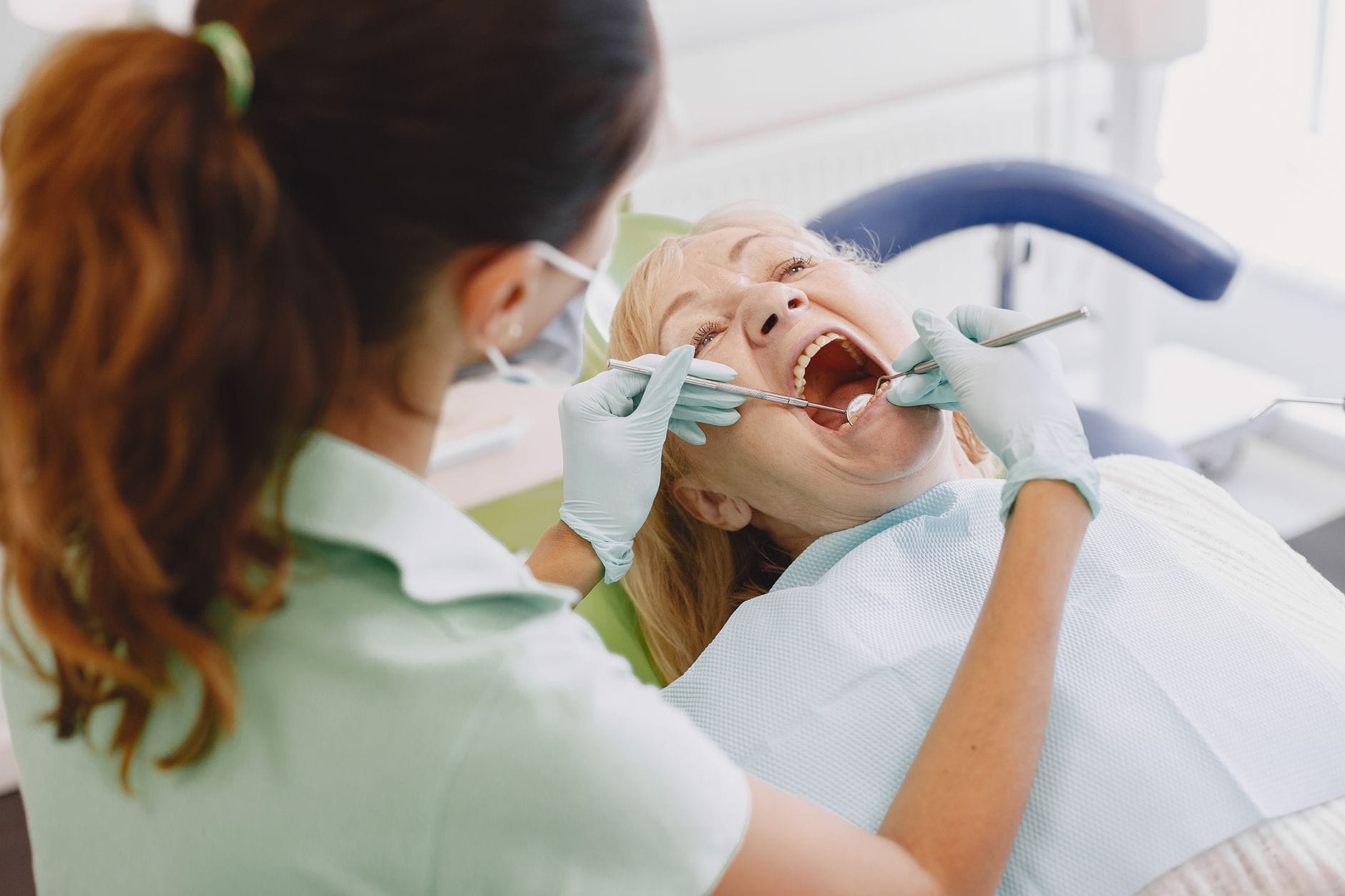 Jak przygotować się do pierwszej wizyty u dentysty – praktyczny poradnik dla dorosłych pacjentów Dentystka bada dorosłego pacjenta na fotelu w gabinecie stomatologicznym