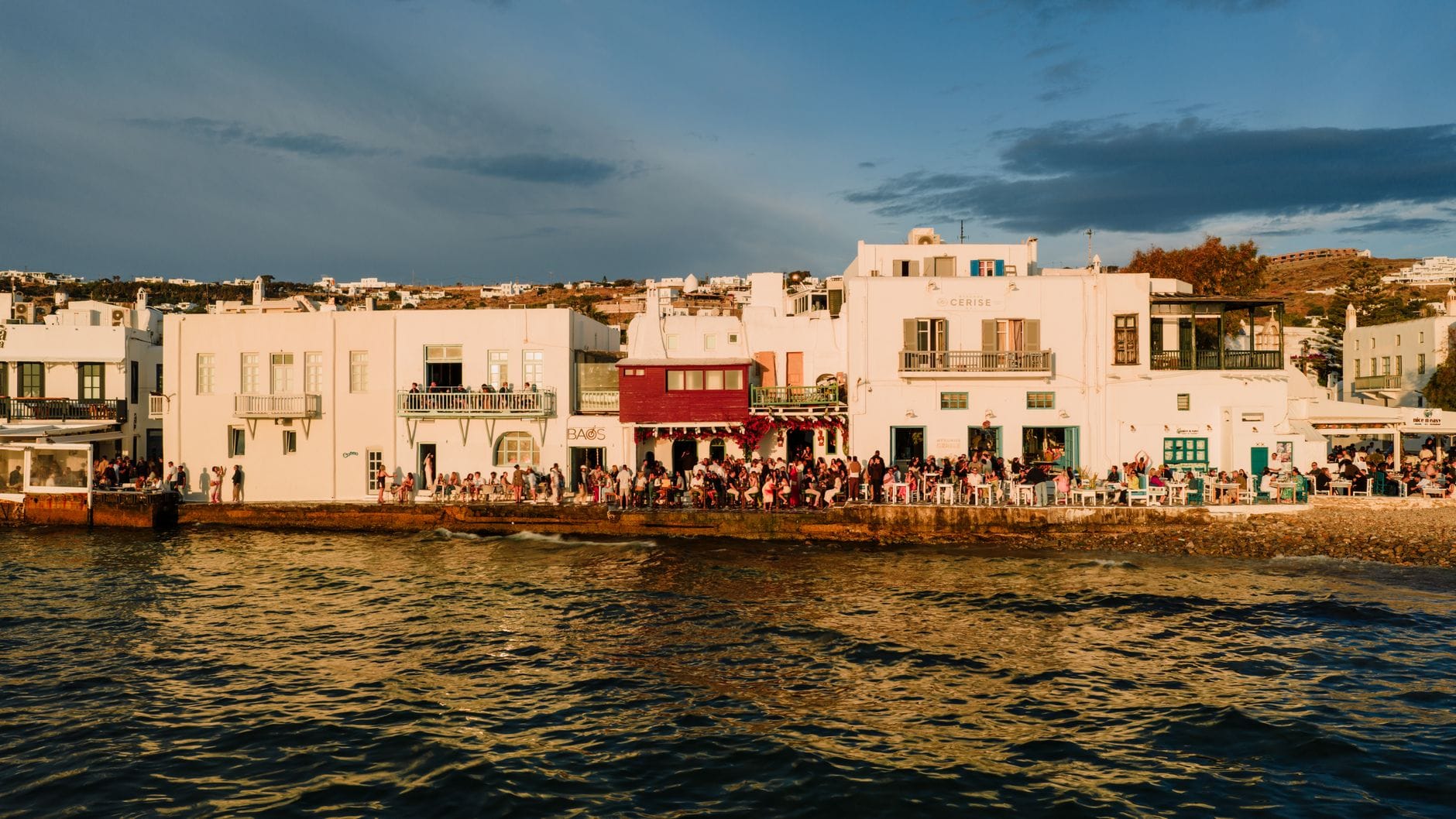 Nadmorska promenada Mykonos o zachodzie słońca z kolorowymi budynkami