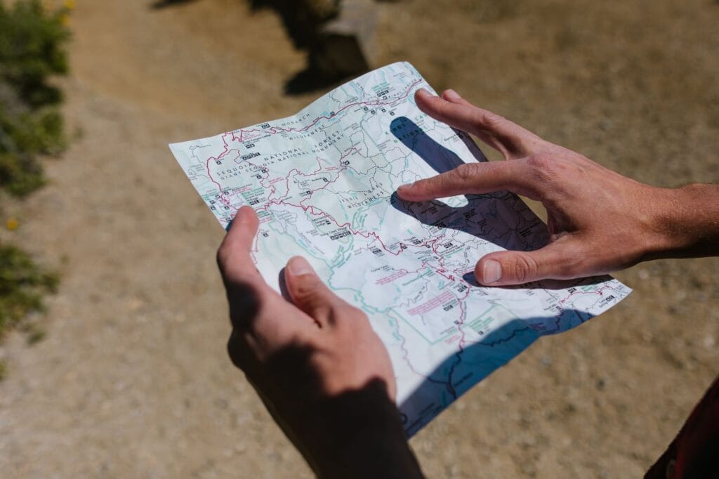 Dłonie trzymające mapę podczas słonecznej wyprawy w terenie